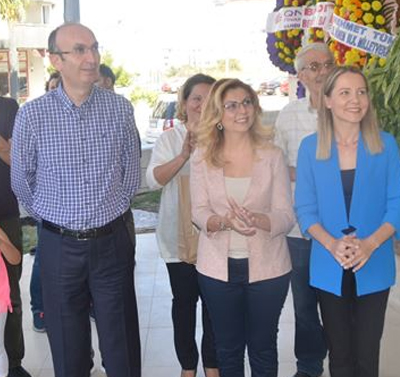 Merkez önünde çiçeklerle karşılanan katılımcılar